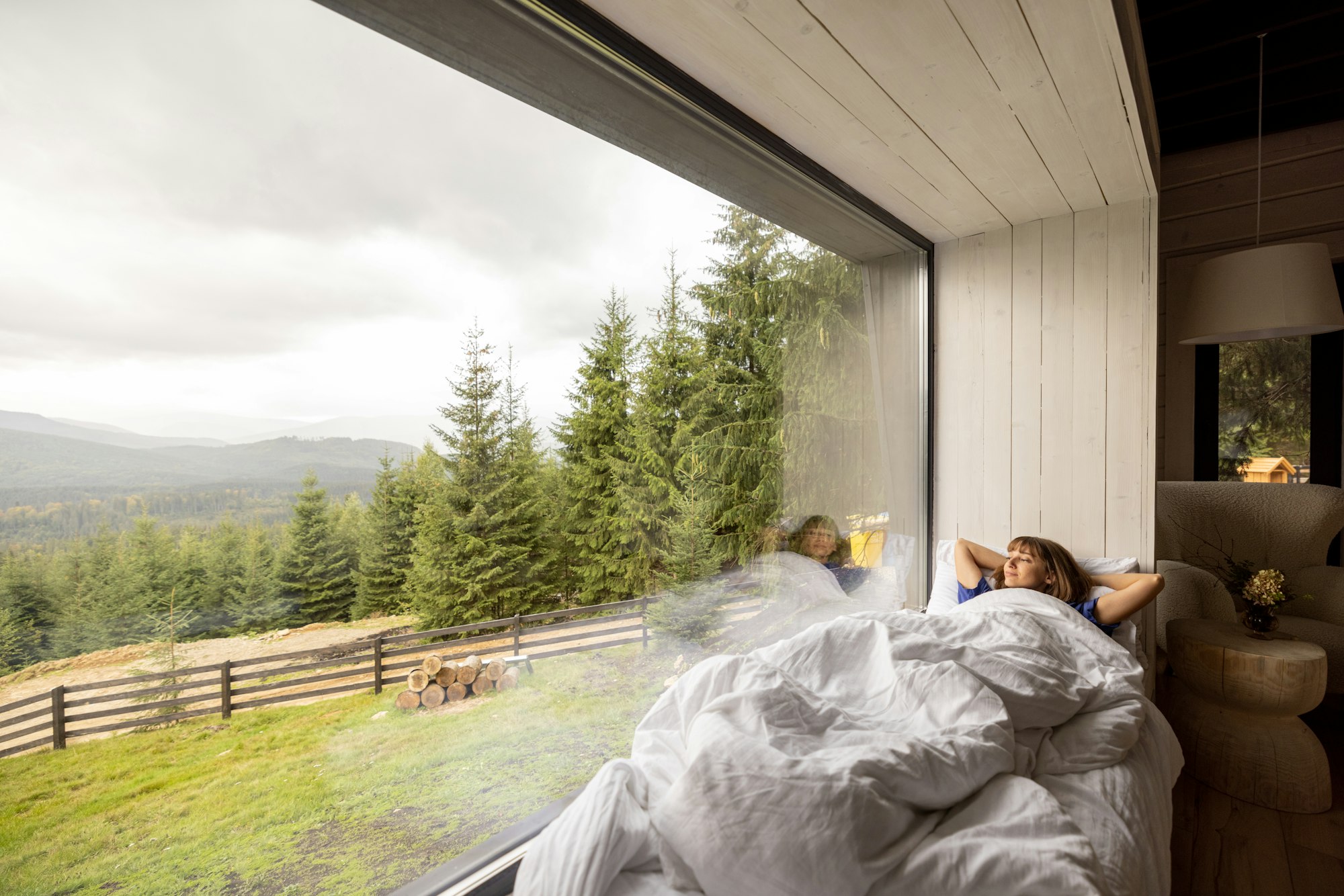 Woman lying on window sill with great view on mountains