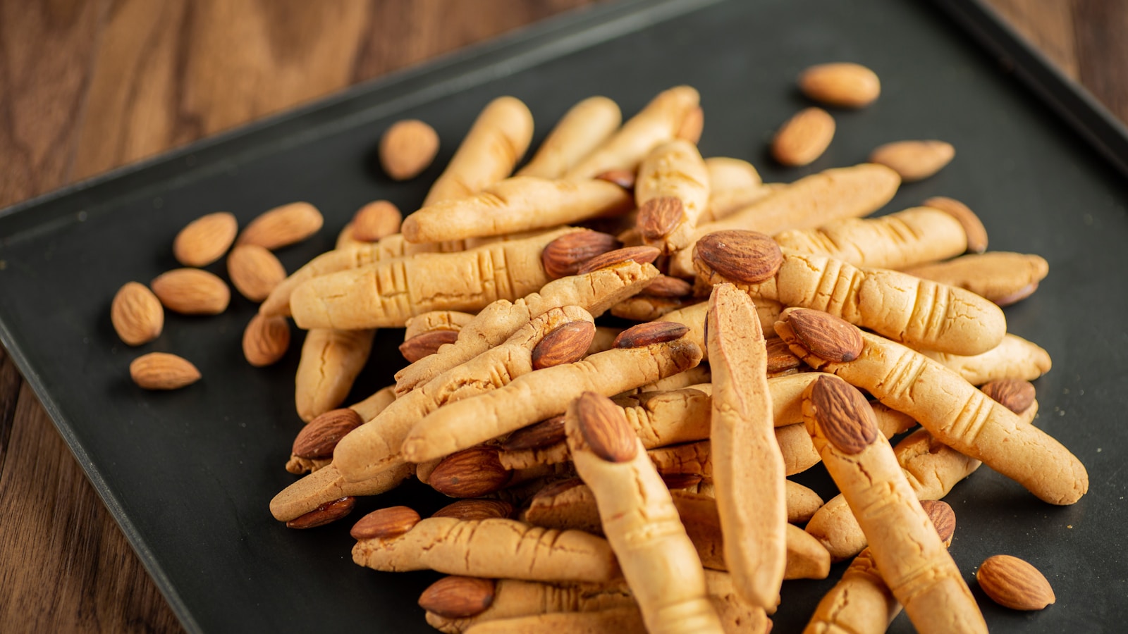 a pile of almonds sitting on top of a black plate